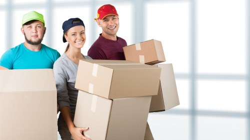 Two movers carrying furniture during a Brent house move